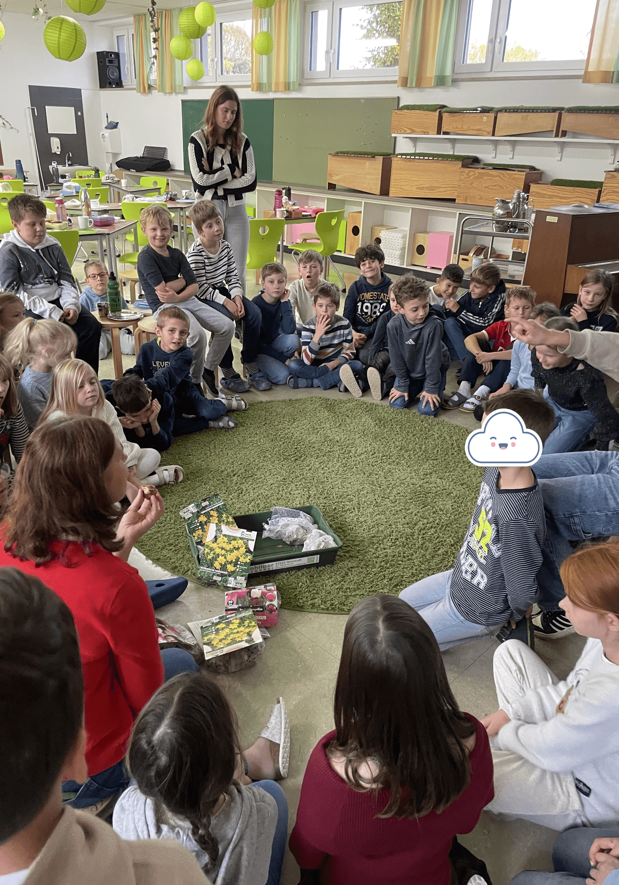 Kinder im Sitzkreis, Lehrerin erzählt über Blumenzwiebeln