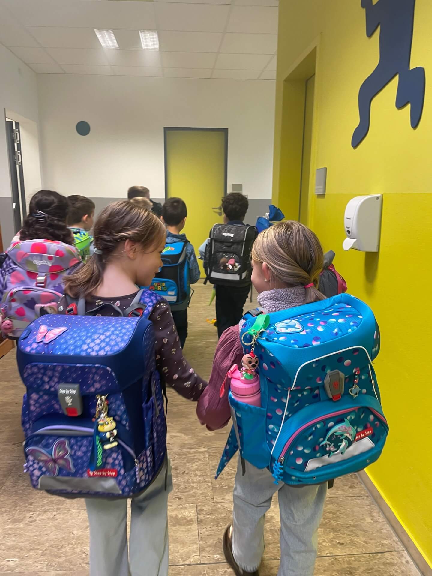 Kinder gehen laufen durch den Gang zum Klassenzimmer